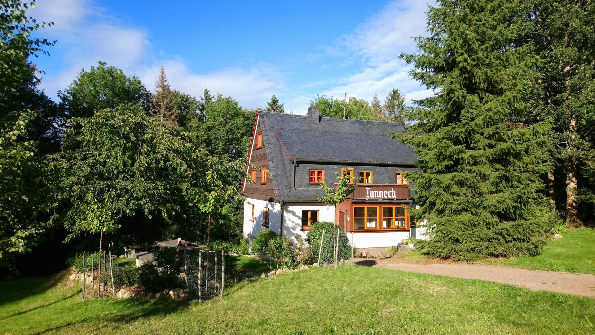 Ferienhaus Tanneck im Sommer, von Bäumen umgeben