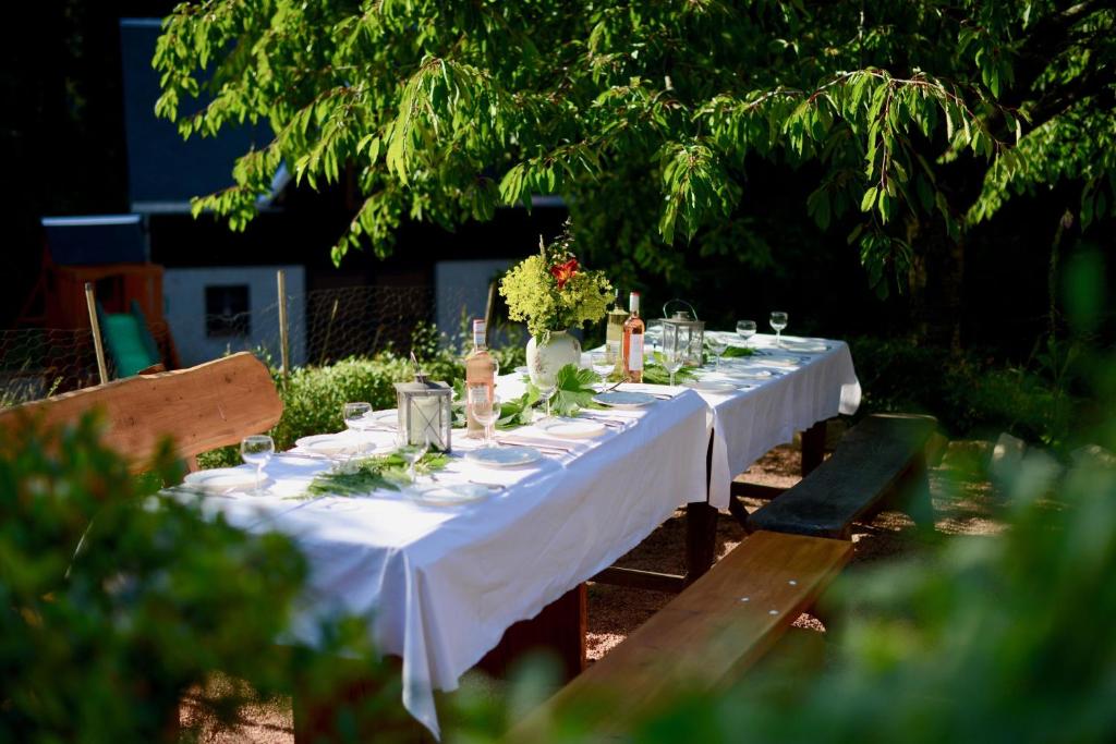 Gedeckte Tafel mit weißer Tischdecke im Garten