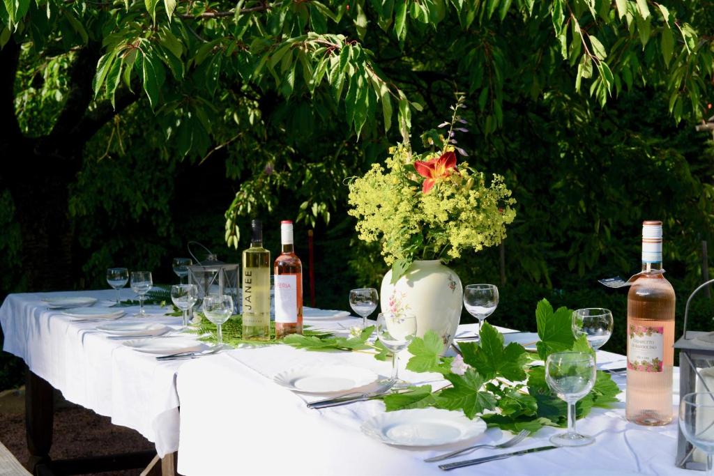 Gartentisch mit Wein, Gläsern und Blumenstrauß
