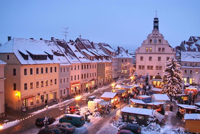 Verschneiter Marktplatz mit Weihnachtsmarkt am Abend