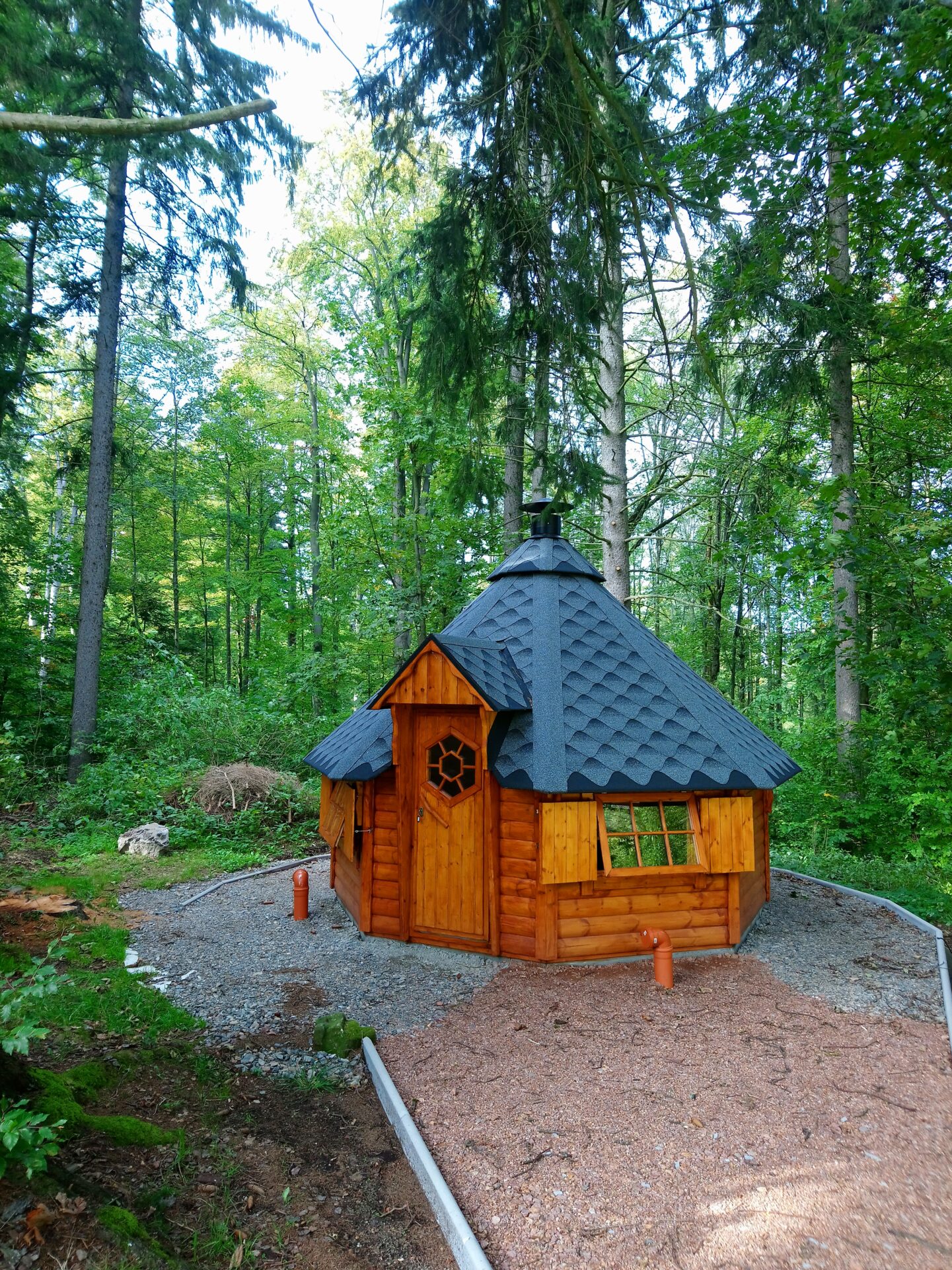 Grillhütte zwischen Bäumen im Garten