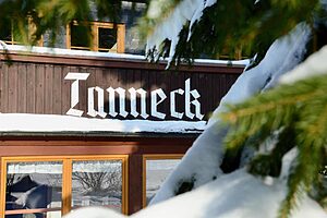 Schriftzug „Tanneck“ an der verschneiten Fassade