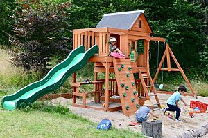 Spielplatz mit Rutsche, Kletterturm und Sandkasten im Garten