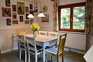 Essecke mit Tisch, Stühlen und Bildern an der Wand