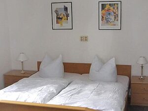 Doppelbett mit weißer Bettwäsche und Nachttischlampen