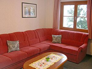 Wohnzimmer mit roter Eckcouch und Couchtisch